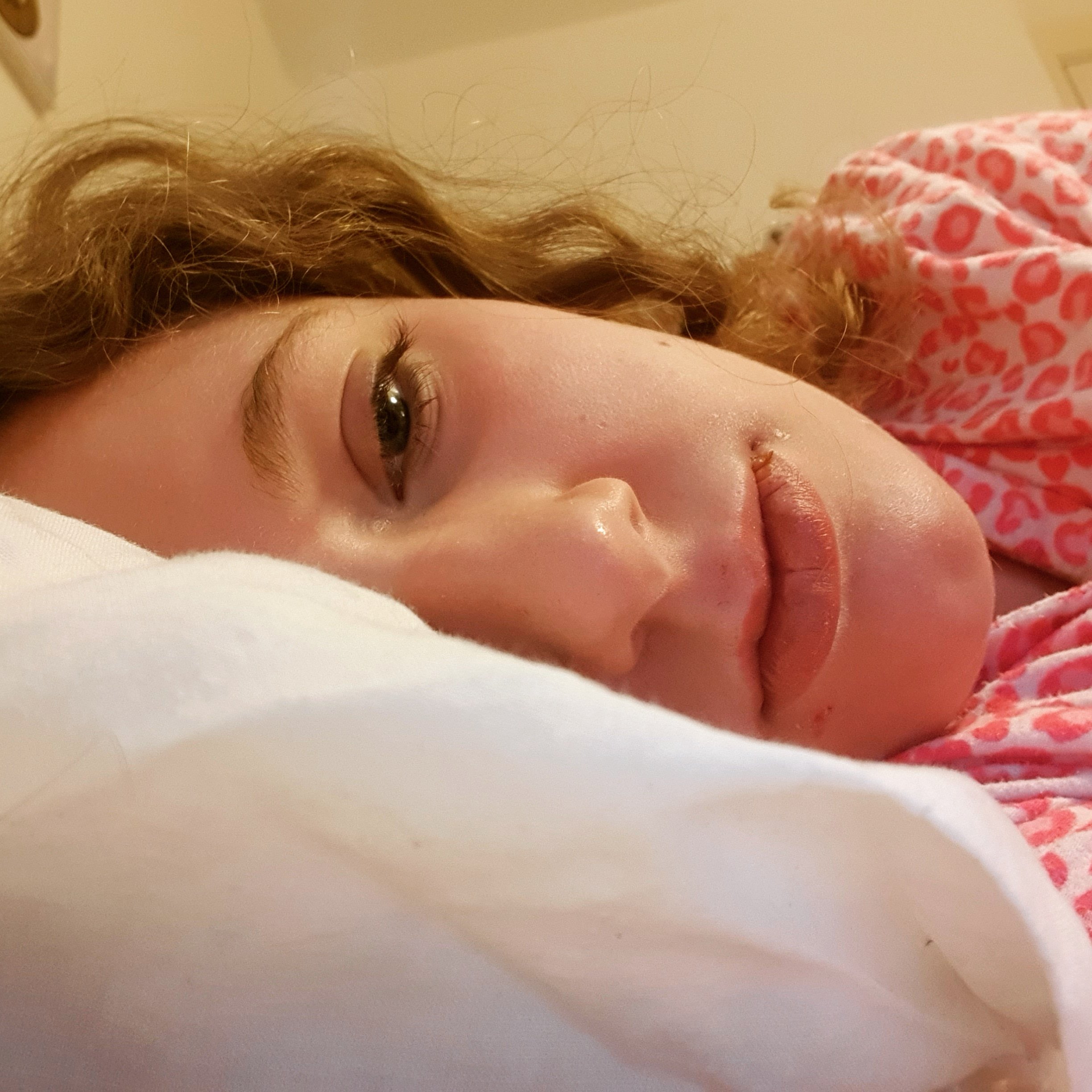 Lay in bed. Taken lying on my side facing the camera with my phone propped up on pillows. I'm wearing pink leopard print pyjamas & my hair is loose.